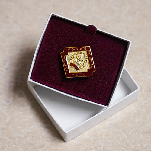 The Mid-State Technical College Nursing pin, used in the College’s nursing pinning ceremony. Mid-State’s unique pin design features a lamp and a book, the lamp being a traditional symbol of excellence.