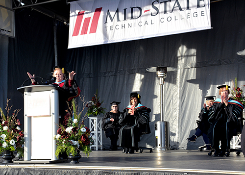 Mid-State Technical College President Dr. Shelly Mondeik addresses the fall 2021 graduating class during commencement on the Wisconsin Rapids Campus, Sunday, December 12. Also on stage, from left: Betty Bruski Mallek, Board of Directors member; Dr. Bobbi Damrow, vice president of Workforce Development & Community Relations; Lynneia Miller, Board of Directors member and Mid-State Distinguished Alumni of the Year recipient; and Dr. Debra Stencil, vice president of Academics.