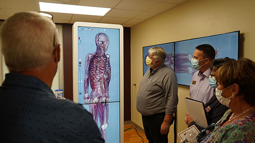 Tours at the Mid-State Simulation Center at the grand opening included state-of- the-art technology, including the Anatomage table, a high-tech 3D anatomy visualization and virtual dissection tool for anatomy and physiology education. Stevens Point Mayor, Mike Wiza, gets a close-up view along with other onlookers. 