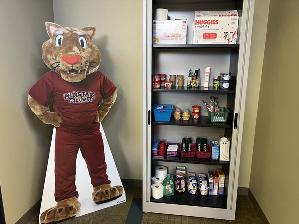 Stevens Point Food Pantry. Shelving with canned and boxed goods, and a mini freezer.