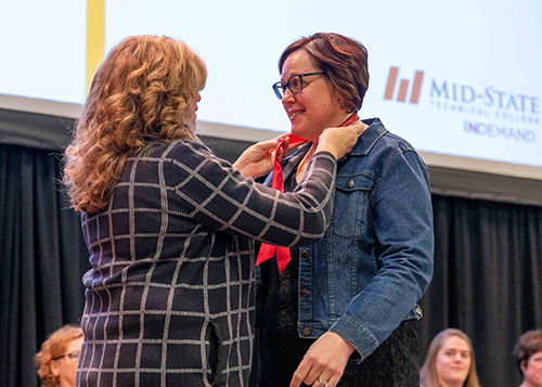 1.	Mid-State Technical College Nursing program graduate Lisa Kiesner receives her nursing pin from Mid-State Nursing Instructor Carolyn Schneebeli during the College’s pinning ceremony on the Wisconsin Rapids Campus, December 16.