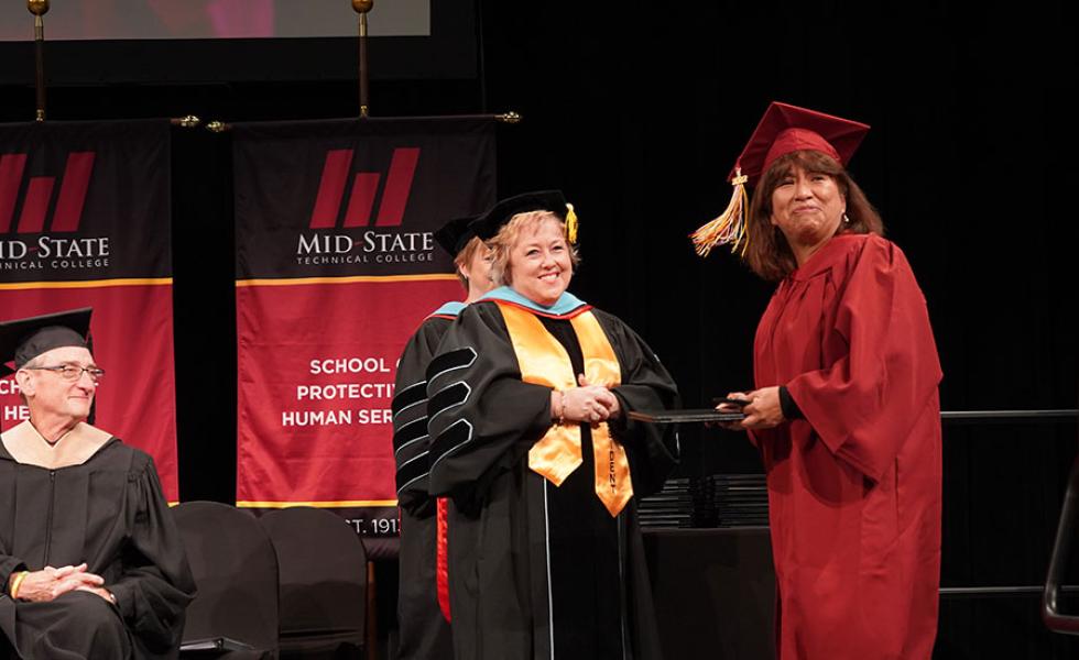 Katty Mansilla, HSED graduate, receives her diploma from Mid-State President Dr. Shelly Mondeik at the College’s commencement ceremony Dec. 10, 2022, on the Wisconsin Rapids Campus.