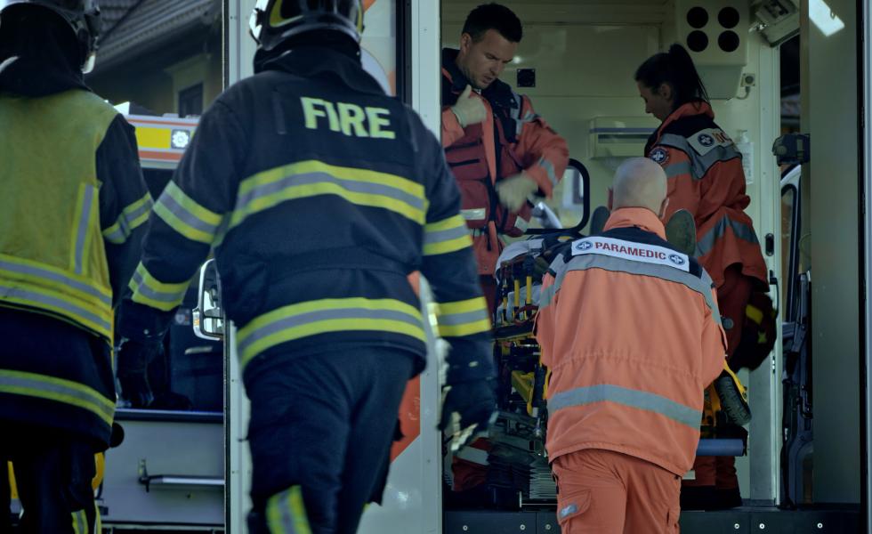 People responding to an emergency in firefighter and paramedic gear.
