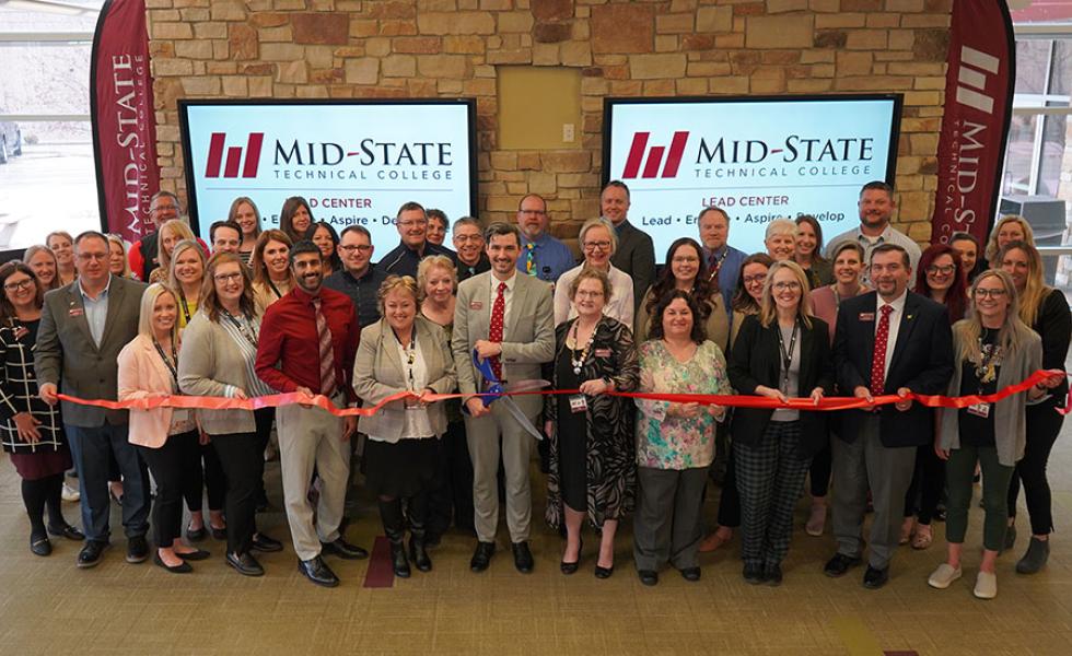 •	Ben Nusz, Mid-State Technical College dean of the Stevens Point Campus and School of Business & IT, holds the ceremonial scissors just before cutting the ribbon on the College’s new LEAD Center on April 1. He is joined by Mid-State’s president, Dr. Shelly Mondeik, left, and other Mid-State leadership and employees.