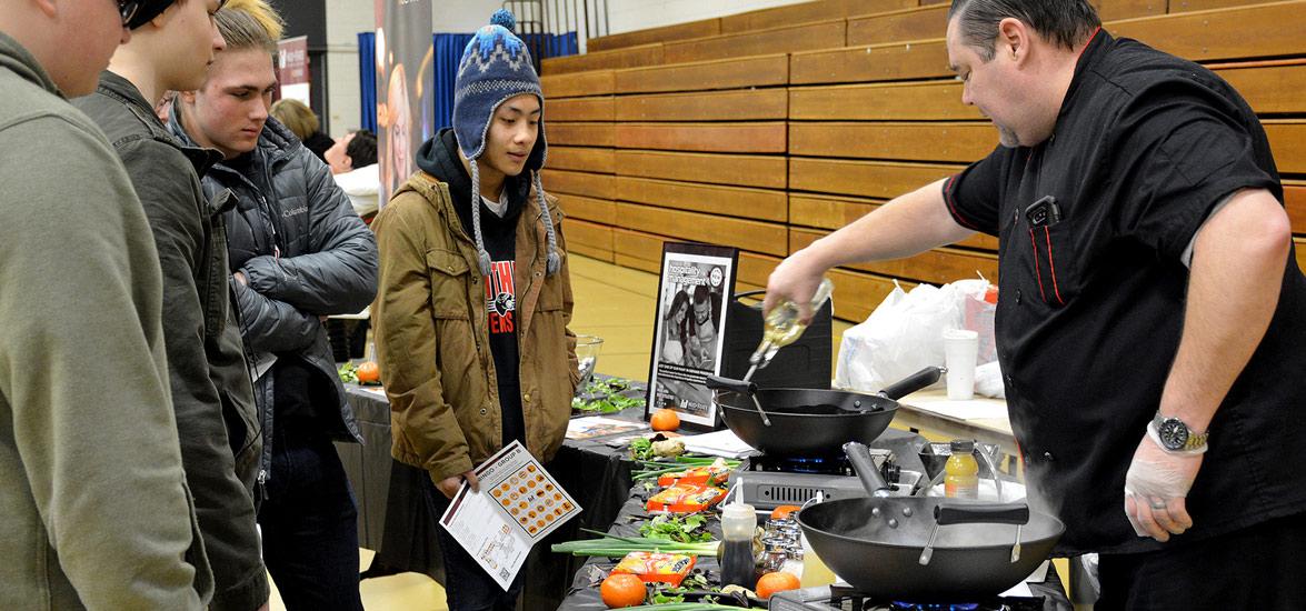 Mid-State Hospitality Management Instructor Paul Kennedy demonstrates his technique for cooking Orange Chicken during a high school outreach event on the College’s Wisconsin Rapids Campus. 