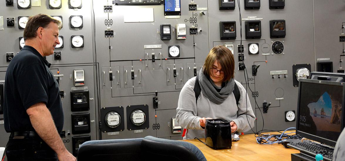 A Program Showcase participant, right, explores Mid-State’s Electrical Power Engineering Technician program by using a bicycle-powered generator to toast a Pop-Tart. Also pictured is Mid-State Electrical Power Engineering Technician Instructor Joe Sroda.