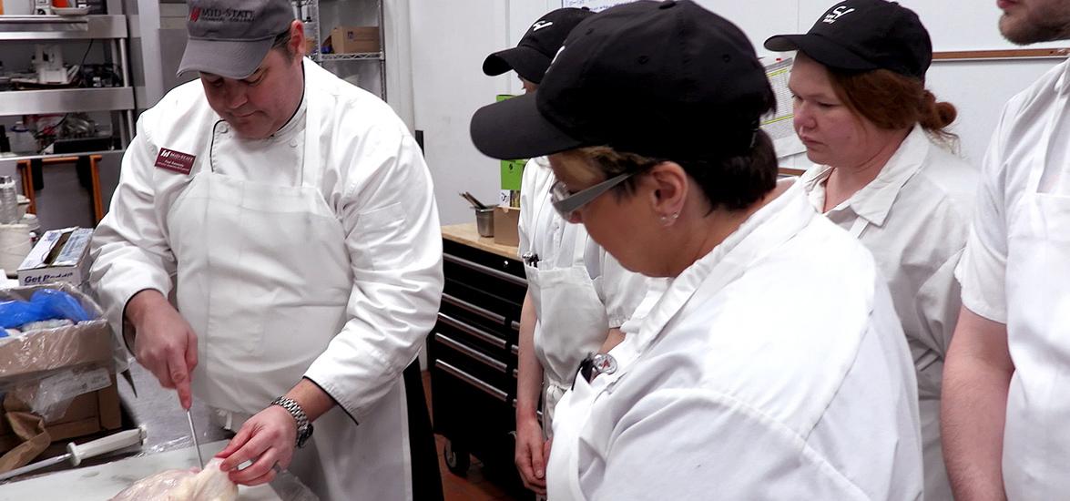Hospitality Management Instructor Paul Kennedy demonstrates quartering a chicken to students in the free spring 2020 Sand Valley Culinary Training program. Students who complete the program earn a local certificate and a job interview for a professional culinary position with Sand Valley in addition to 10 college credits that can be applied to Mid-State’s Hospitality Management associate degree program.  