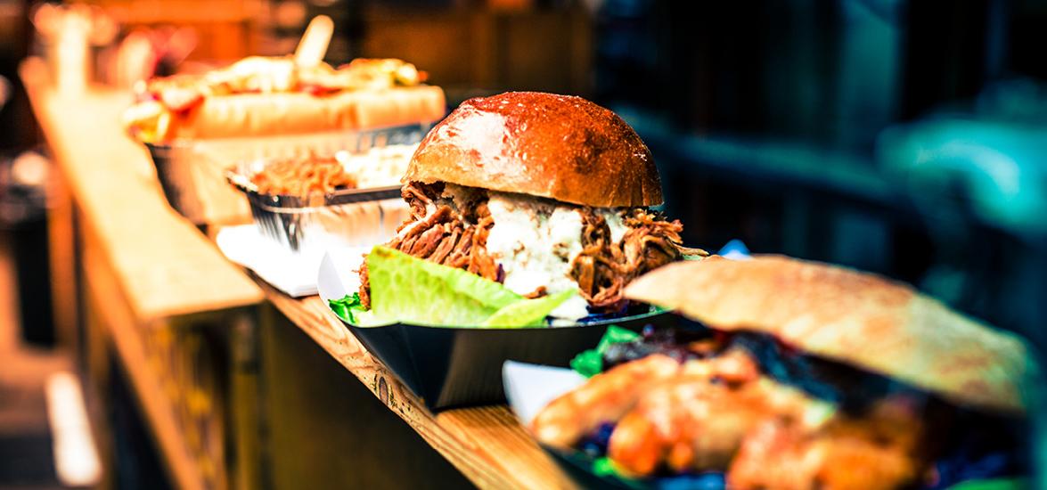 Several prepared dishes lined up on a bar and ready to be served to customers in a restaurant.