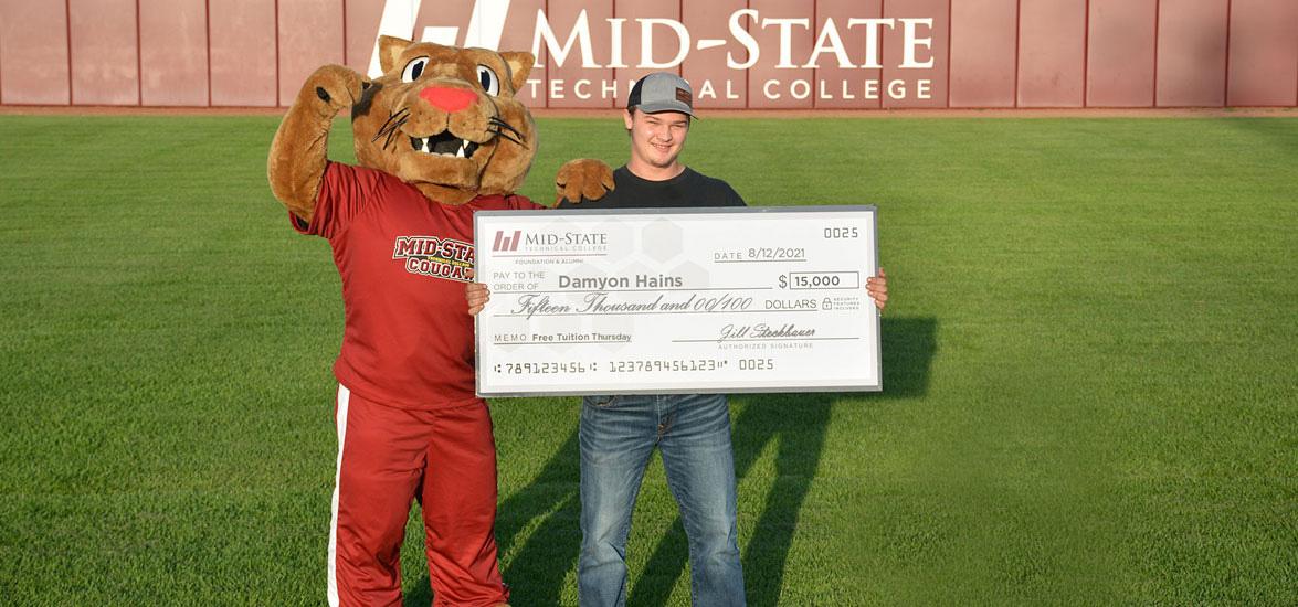 Damyon Hains with Mid-State’s mascot, Grit, just after winning the $15,000 grand prize in Mid-State’s Free Tuition Thursdays promotion at Witter Field in Wisconsin Rapids, Aug. 12. The award will offset the cost of his attendance at Mid-State while he pursues his Diesel & Heavy Equipment Technician associate degree.