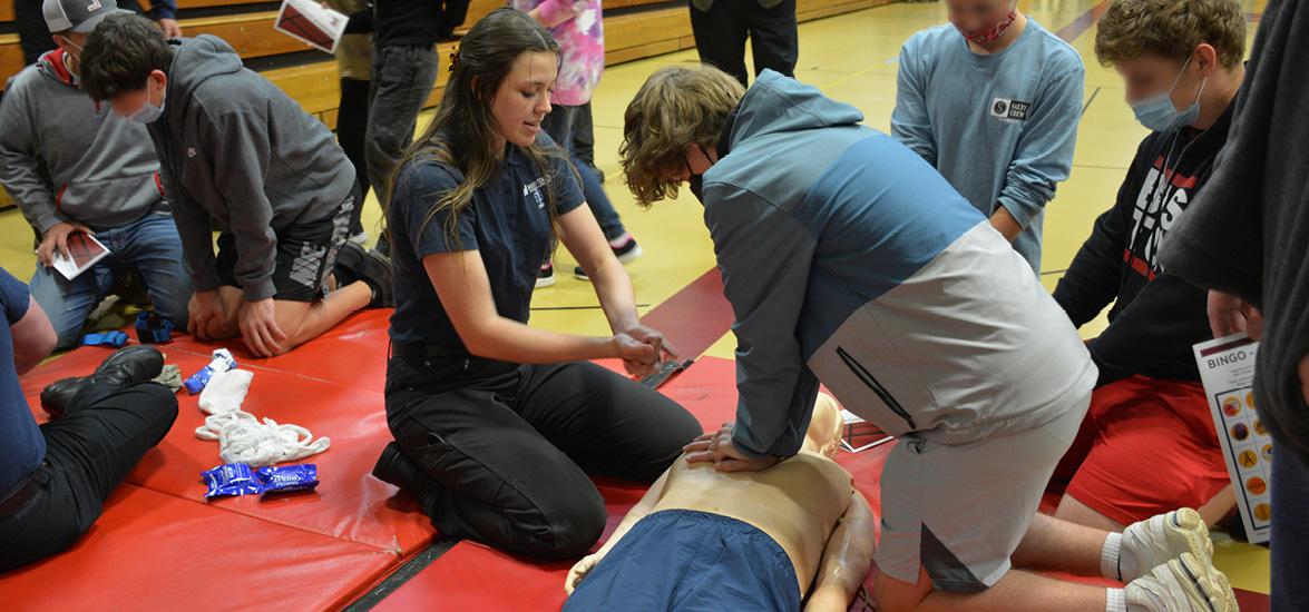 A Program Showcase participant practices CPR technique on a high-fidelity manikin as part of the career exploration activity for Mid-State’s Paramedic Technician program.