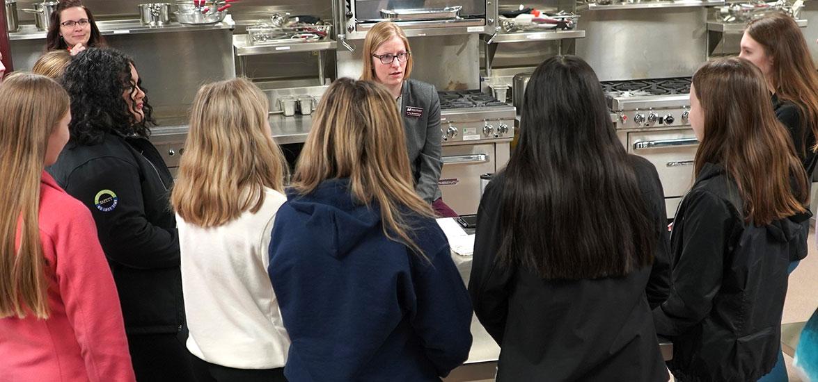 Dean of Business and Technology Missy Skurzewski-Servant discusses culinary arts with several high school students participating in the spring Program Showcase event at Mid-State Technical College.