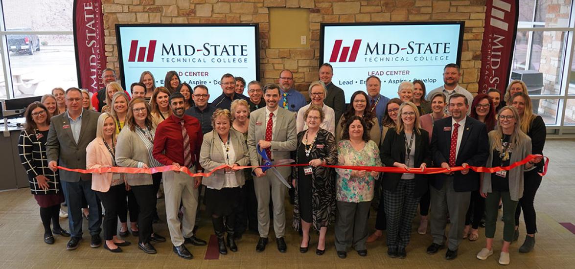 • Ben Nusz, Mid-State Technical College dean of the Stevens Point Campus and School of Business & IT, holds the ceremonial scissors just before cutting the ribbon on the College’s new LEAD Center on April 1. He is joined by Mid-State’s president, Dr. Shelly Mondeik, left, and other Mid-State leadership and employees.