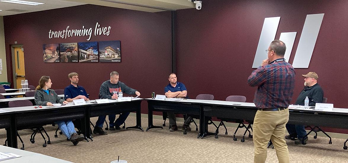 Students in Mid-State’s supervisory training for Domtar sit at tables and listen to instructor Ted Melby