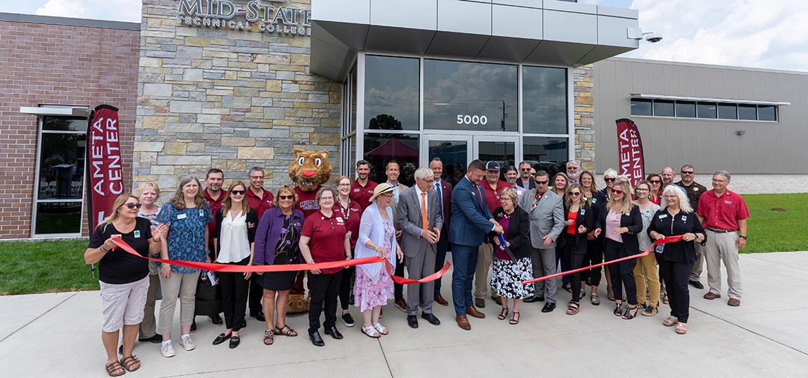Wisconsin Gov. Tony Evers looks on while Mid-State Technical College’s Dean of the School of Applied Technology Ryan Kawski and President Dr. Shelly Mondeik share ribbon-cutting duties at the AMETA Center grand opening. Wayne H. Bushman, major campaign contributor and land donor, stands behind Kawski and Mondeik. Also pictured: members of Mid-State’s Board of Directors, Foundation Board of Directors and faculty and staff; Findorff & Son Inc. Presiden