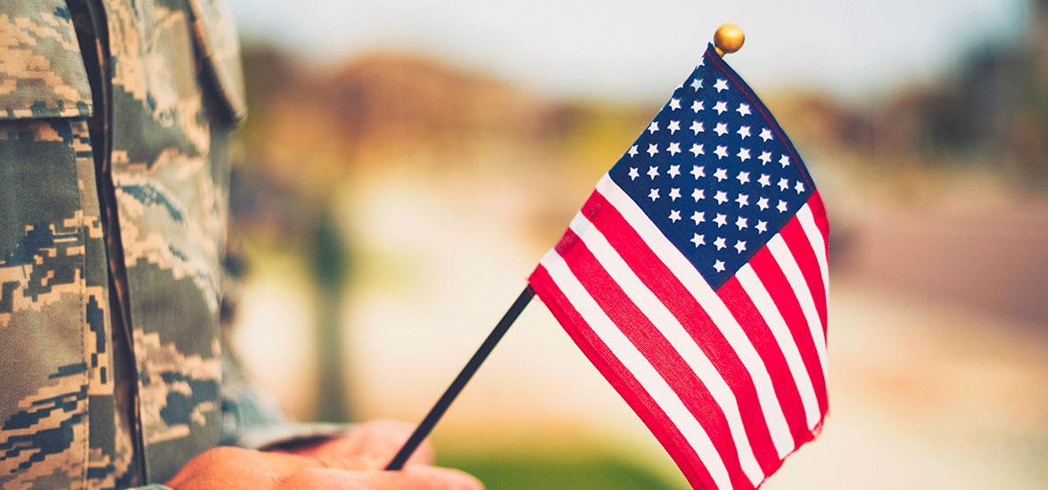 Service member holding an American flag.