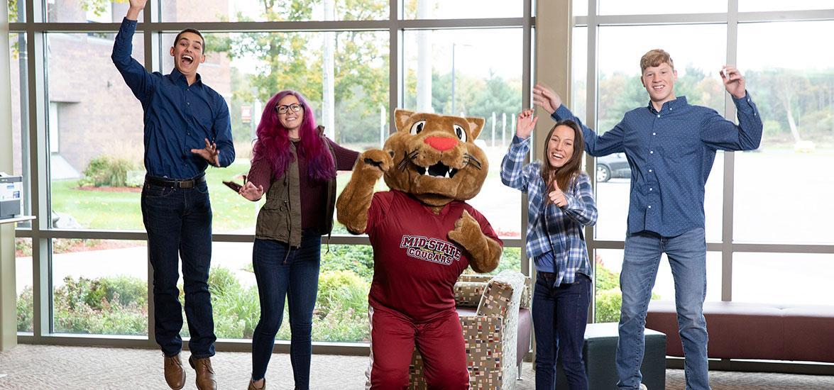 Mid-State students jumping with the mascot, Grit.