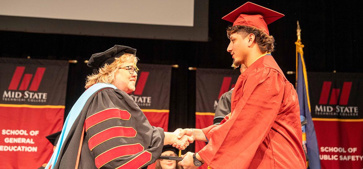 Mid-State President Dr. Shelly Mondeik congratulates a graduate during the presentation of diplomas at the College’s fall commencement on the Wisconsin Rapids in December. Spring commencement will be held on Saturday, May 17, on the Wisconsin Rapids Campus.