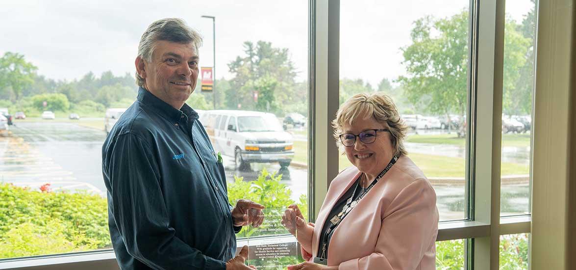 WATEA Co-Founder Jerry Brickner, left, and Mid-State Technical College President Dr. Shelly Mondeik hold a plaque of appreciation presented by Mid-State to WATEA honoring their three-year partnership to launch and deliver a free shuttle service for students. The plaque was presented at the shuttle celebration event held on Mid-State’s Wisconsin Rapids Campus, June 16.