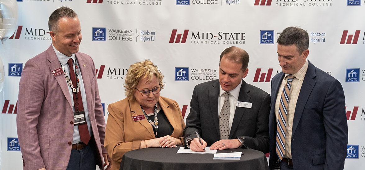 Leadership from Mid-State Technical College and Waukesha County Technical College sign the agreement to offer a new shared AI Data Specialist associate degree at a Feb. 6 signing event at the AMETA Center. 