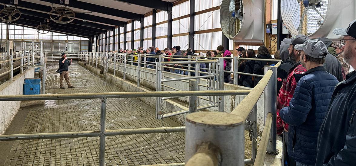 Luke Luchterhand, co-owner of Elusive Hill Dairy, describes the farm’s gate system, footbath and herd health monitoring system to participants at the 49th Annual Farm Tour.