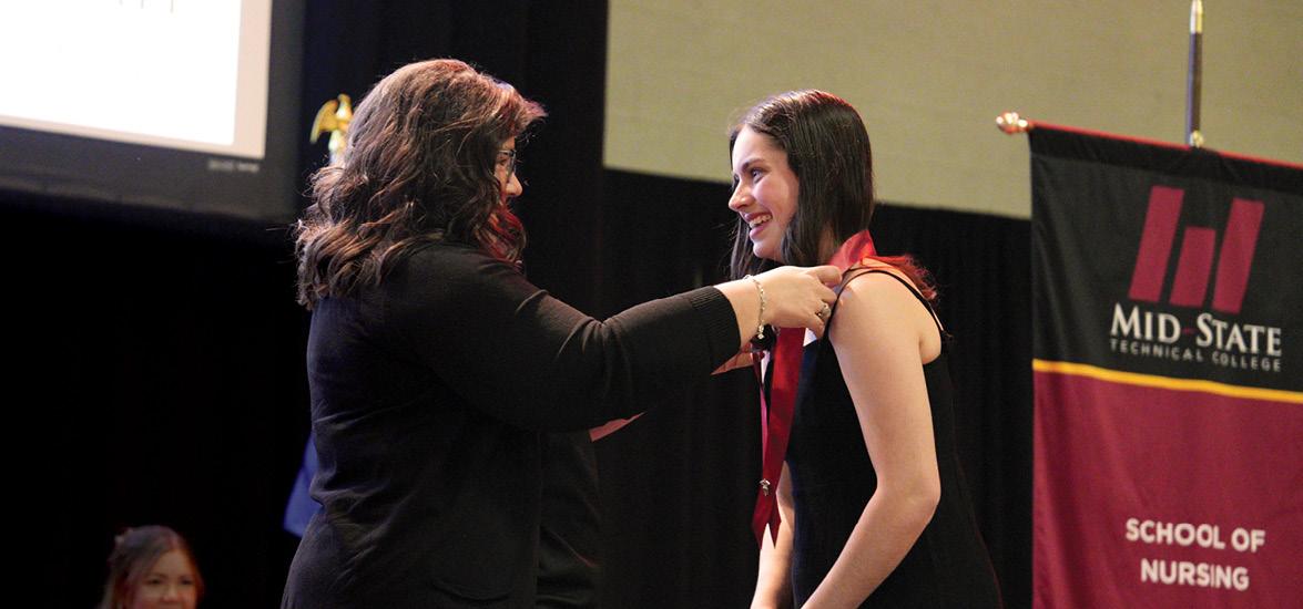Mid-State Technical College Nursing program graduate Katie Hames receives her nursing pin from Mid-State Nursing Instructor Kristi Busscher during the College’s pinning ceremony on the Wisconsin Rapids Campus, May 19.