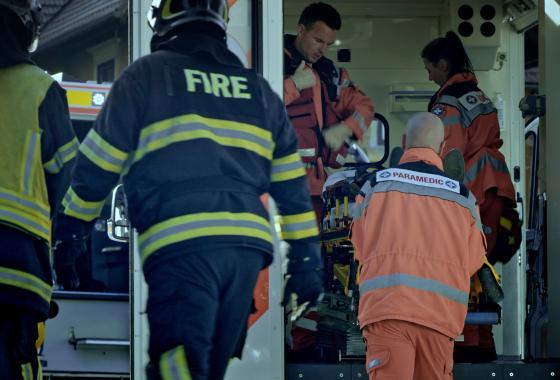 People responding to an emergency in firefighter and paramedic gear.