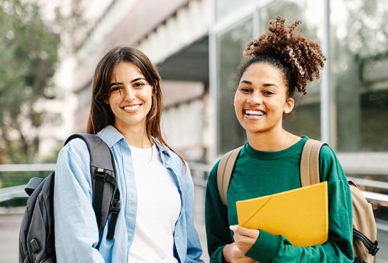 Two students with backpacks and folders.