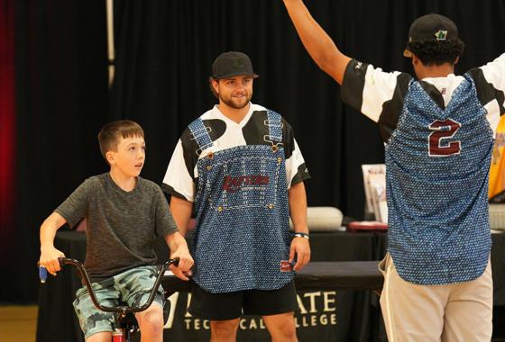 A Rafters Meet and Greet participant competes in tricycle racing against a Rafters player at the “Rafters Meet-and-Greet” and “Cuts 4 Kids” event held on Mid-State’s Wisconsin Rapids Campus, June 11.