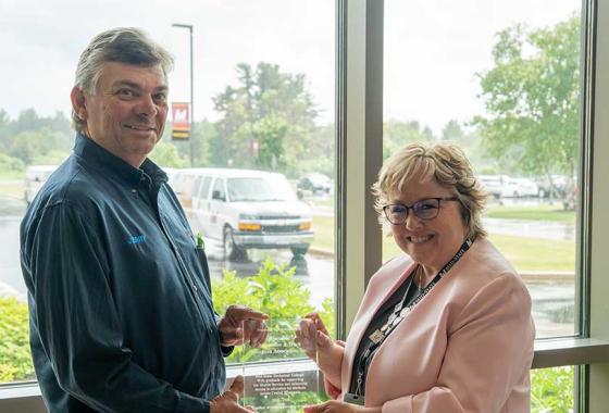  WATEA Co-Founder Jerry Brickner, left, and Mid-State Technical College President Dr. Shelly Mondeik hold a plaque of appreciation presented by Mid-State to WATEA honoring their three-year partnership to launch and deliver a free shuttle service for students. The plaque was presented at the shuttle celebration event held on Mid-State’s Wisconsin Rapids Campus, June 16.