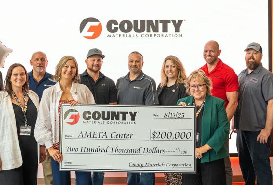 From left, Rebecca Sonnentag, executive vice president of marketing and communications at County Materials Corporation, and Dr. Shelly Mondeik, president of Mid-State Technical College, hold up the $200,000 donation from County Materials Corporation in support of the AMETATM Center, surrounded by staff from both organizations. The check presentation took place at the AMETA Center, in Stevens Point, Wednesday, Aug. 13, 2025.