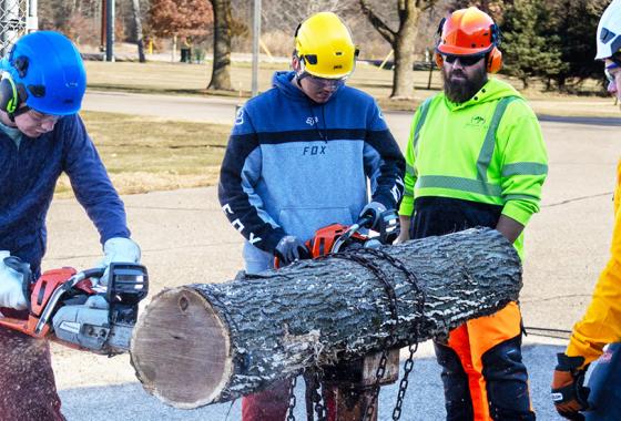 Tree Tech 2025 participants get chainsaw training by arboriculture professionals at the Wisconsin Rapids Campus.