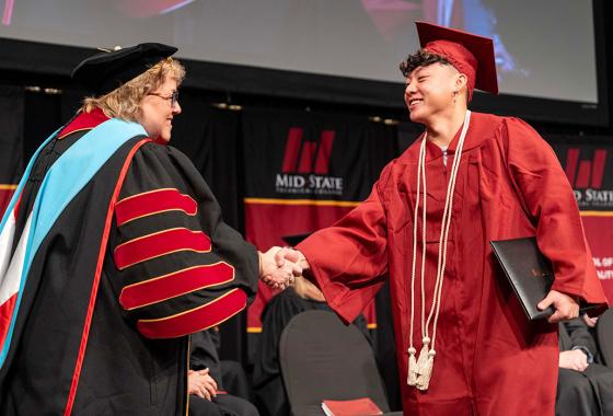Mid-State Technical College President Dr. Shelly Mondeik congratulates a graduate during the presentation of diplomas at Mid-State’s fall commencement on the Wisconsin Rapids Campus, Dec. 13, 2025.