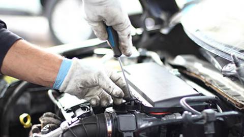 A mechanic's hands above an engine